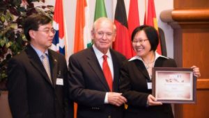 Ying Sa, right, founder and CEO of Community CPA & Associates, accepted the 2008 Decade of Service Award from former Governor Robert Ray (center) and the Chinese Consul General Ping Huang (left).